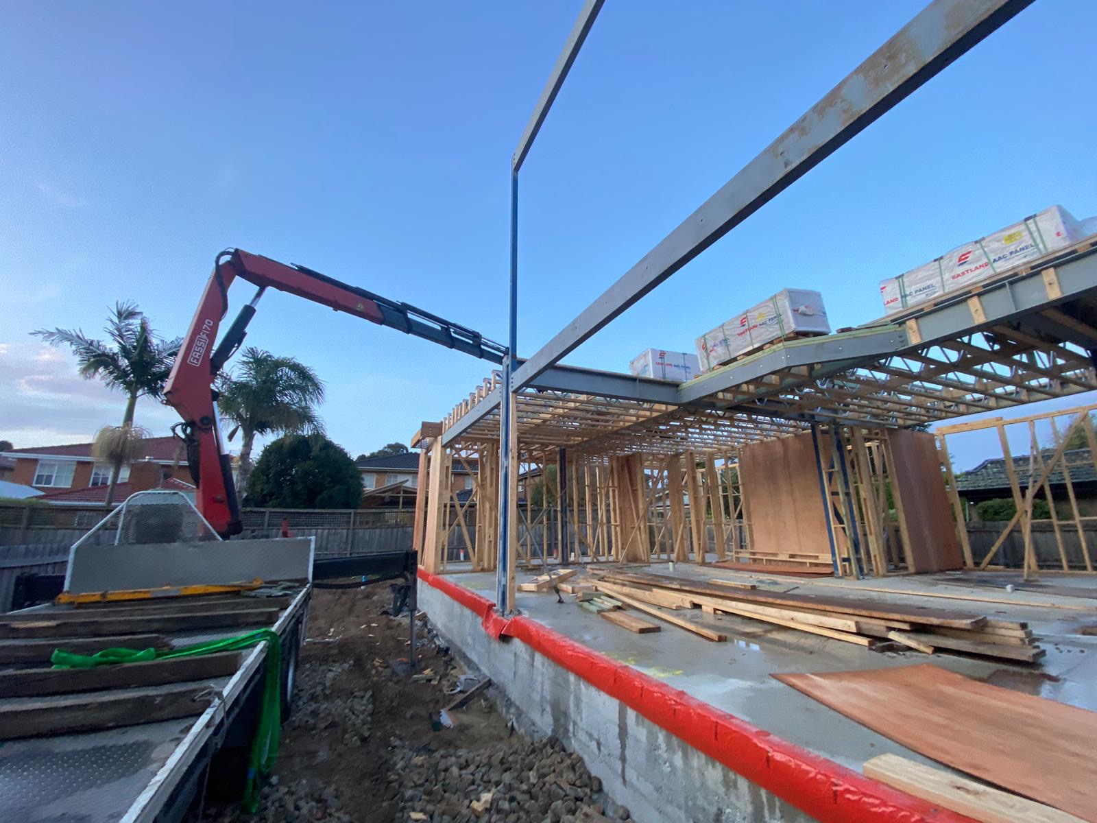 Ultimate Crane Truck delivering heavy building materials to a residential construction site for scaffold support in Melbourne.