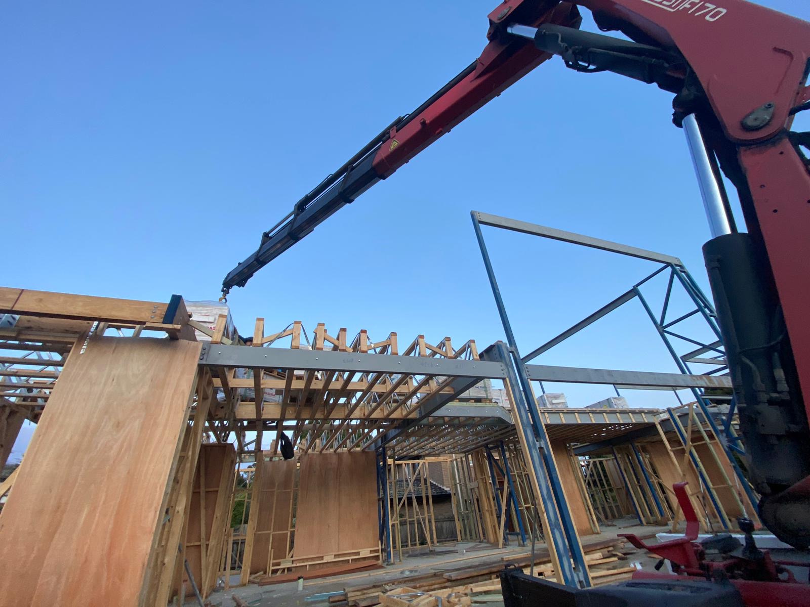Hiab truck hire installation of building materials onto a timber-framed structure in Melbourne by Ultimate Crane Trucks.